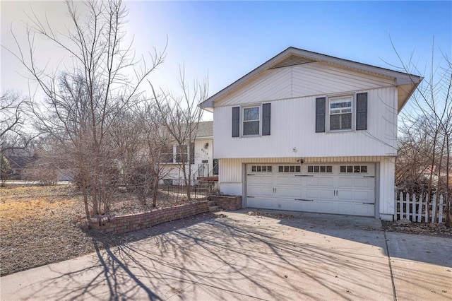 split level home featuring concrete driveway and a garage