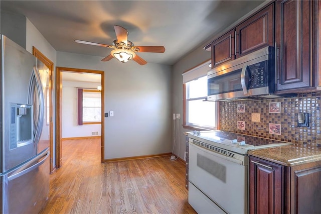 kitchen featuring stainless steel appliances, tasteful backsplash, a healthy amount of sunlight, and light wood-style flooring