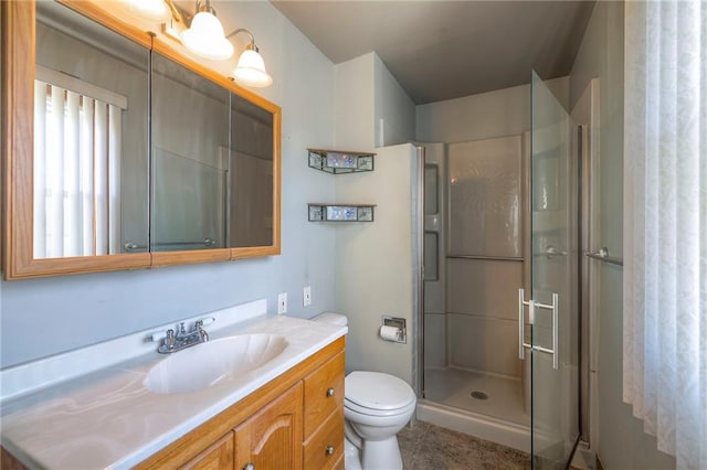 bathroom featuring a stall shower, toilet, and vanity