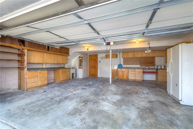 garage featuring white fridge with ice dispenser