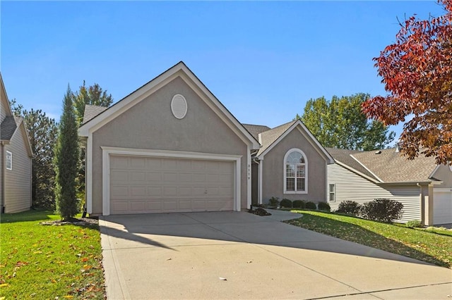 ranch-style home with a garage, a front yard, concrete driveway, and stucco siding