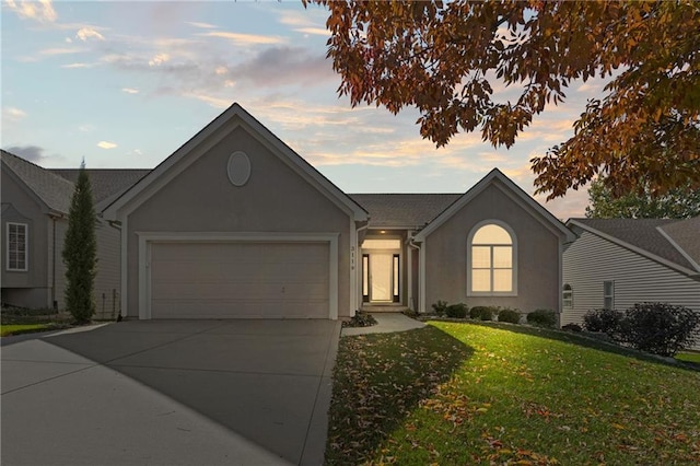 ranch-style house featuring a garage, a front lawn, concrete driveway, and stucco siding