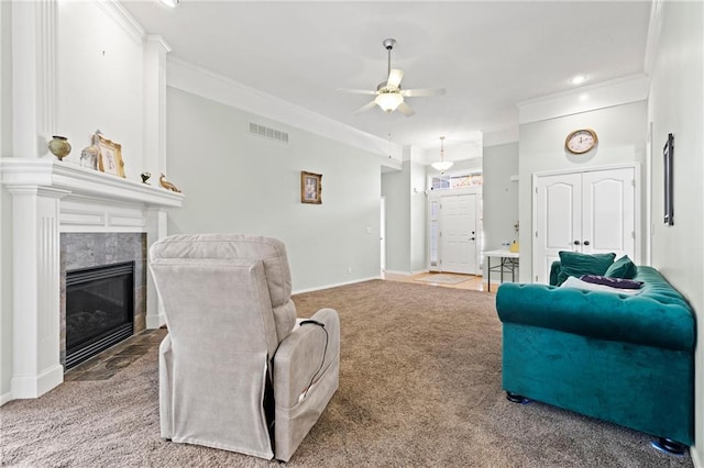 living area featuring carpet, visible vents, crown molding, and a tile fireplace