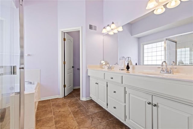 bathroom with a garden tub, double vanity, visible vents, a stall shower, and a sink