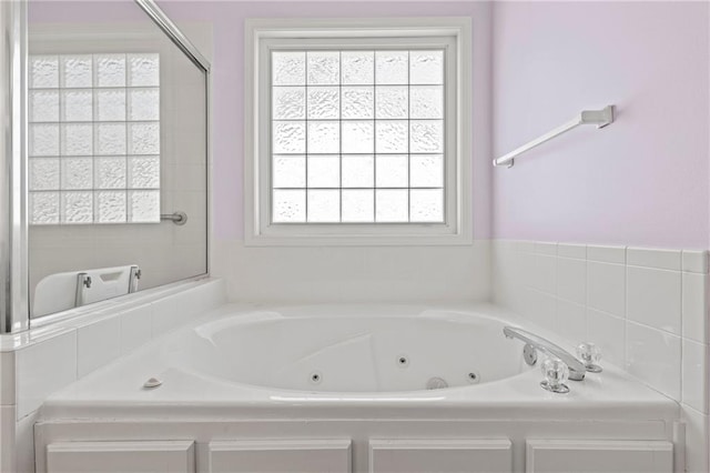 full bathroom with a jetted tub