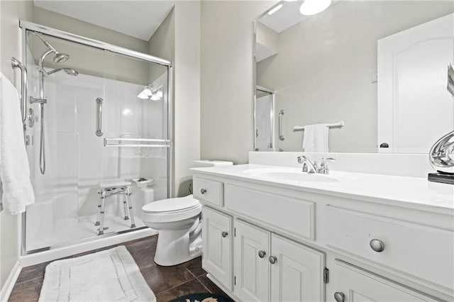 full bathroom featuring a stall shower, vanity, and toilet