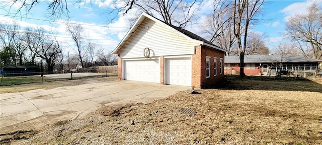 view of property exterior featuring fence, an outbuilding, and brick siding