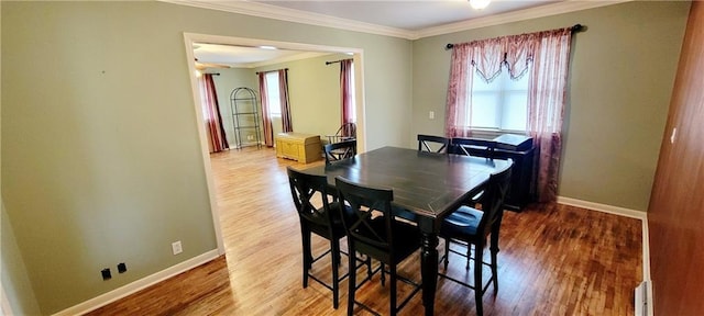 dining area featuring ornamental molding, wood finished floors, and baseboards