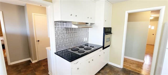 kitchen featuring electric cooktop, stainless steel oven, under cabinet range hood, white cabinetry, and backsplash