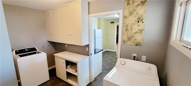 washroom with independent washer and dryer, cabinet space, and baseboards