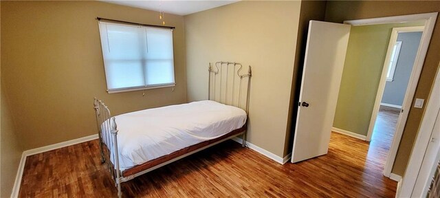 bedroom featuring wood finished floors and baseboards