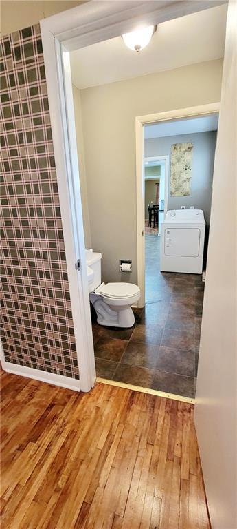 bathroom featuring toilet, washer / clothes dryer, and hardwood / wood-style floors