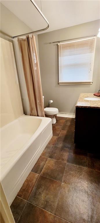 bathroom featuring washtub / shower combination, vanity, and toilet