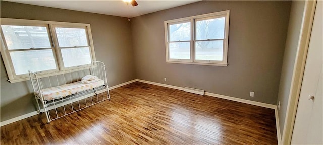 unfurnished room with plenty of natural light, wood finished floors, and baseboards