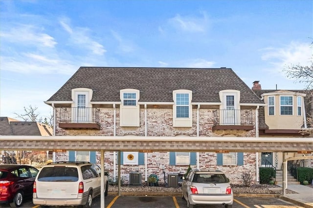 view of property featuring covered parking and central AC