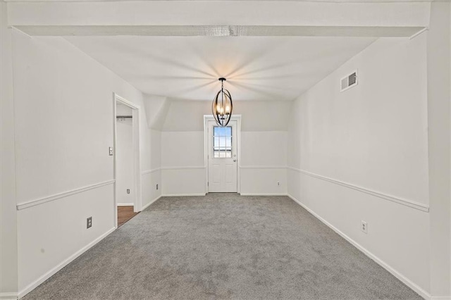 empty room with visible vents, carpet floors, baseboards, and a chandelier