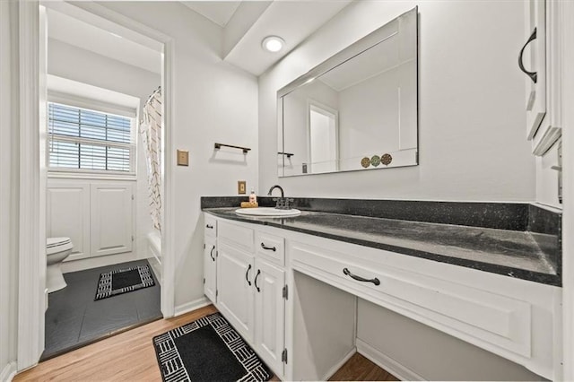 bathroom featuring shower / tub combo with curtain, toilet, wood finished floors, and vanity