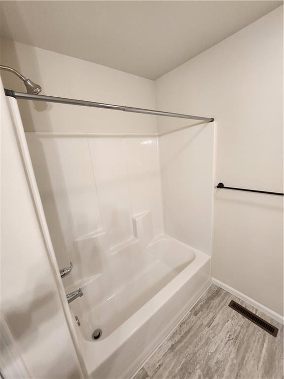 full bath with shower / bath combination, wood finished floors, visible vents, and baseboards