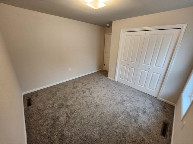 unfurnished bedroom featuring a closet, carpet flooring, visible vents, and baseboards