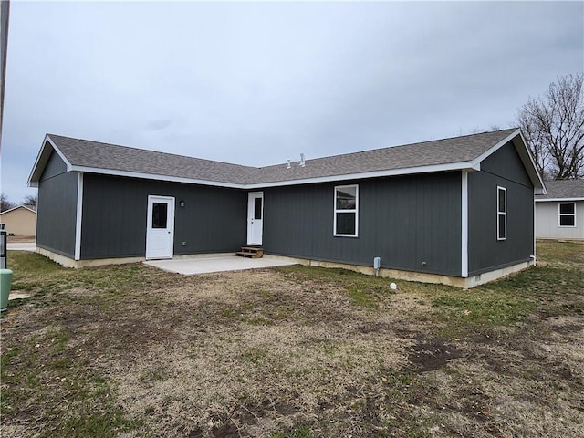 rear view of house featuring a shingled roof and a patio