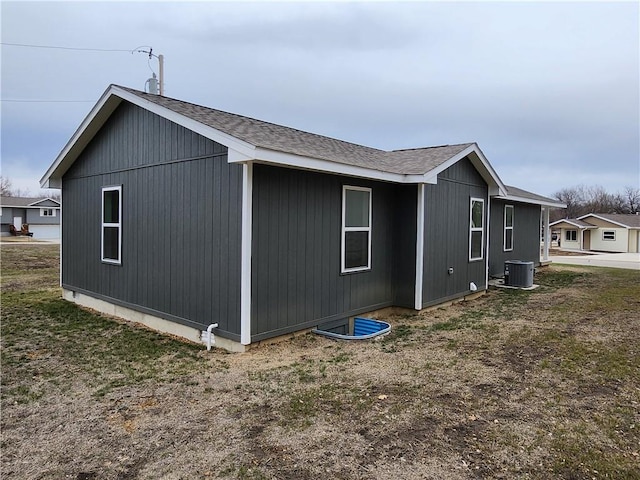 view of property exterior with cooling unit and roof with shingles