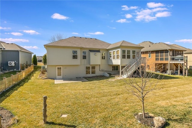 back of property featuring fence, stairs, a yard, a sunroom, and a patio