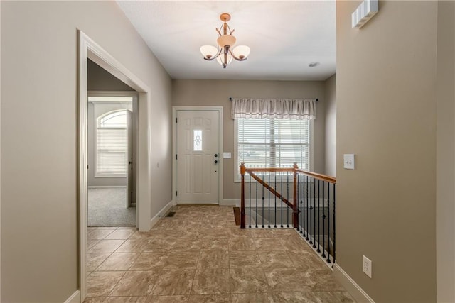 foyer with a chandelier and baseboards