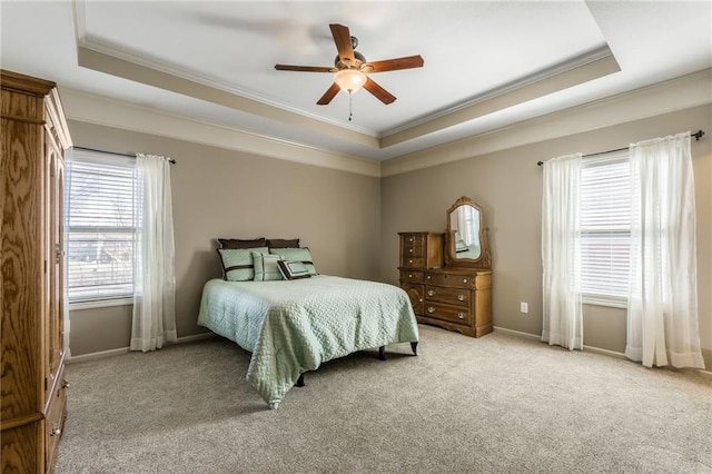 bedroom with a tray ceiling, baseboards, light colored carpet, and crown molding