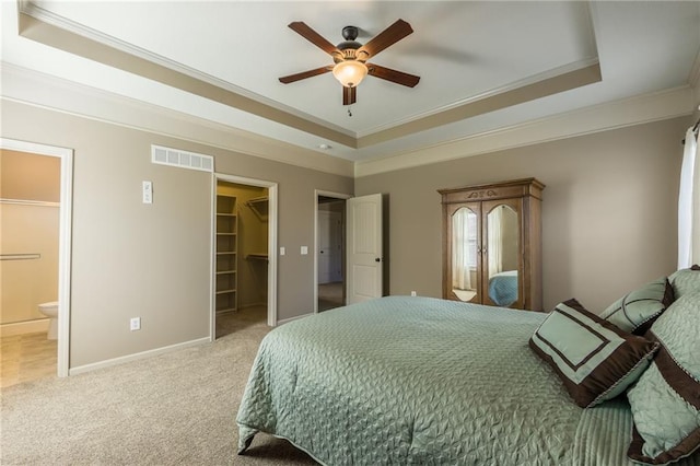 bedroom featuring visible vents, ornamental molding, a tray ceiling, and carpet floors