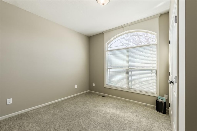 spare room with baseboards and carpet