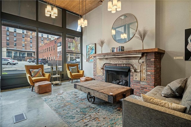 living room with a fireplace, visible vents, a high ceiling, concrete flooring, and wooden ceiling