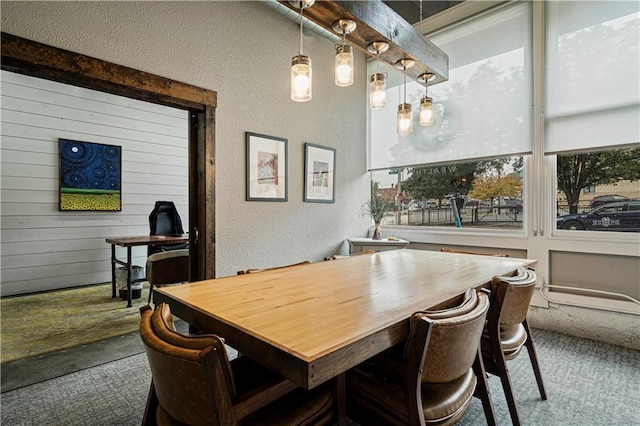 carpeted dining area featuring a textured wall