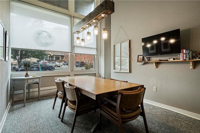 dining space with carpet floors, a textured wall, and baseboards