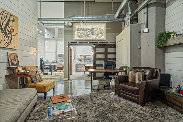 home office with wood walls and a towering ceiling