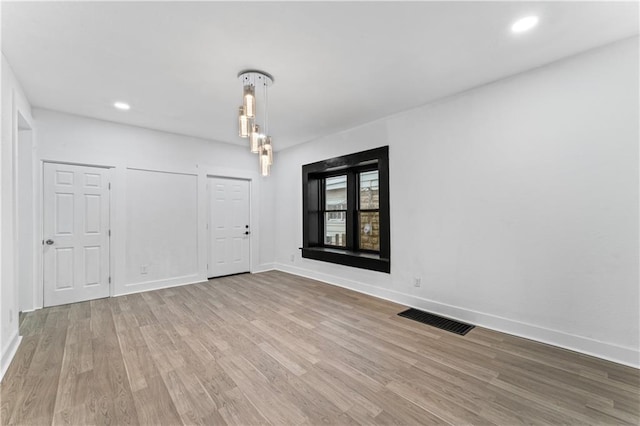 spare room with recessed lighting, wood finished floors, visible vents, and baseboards