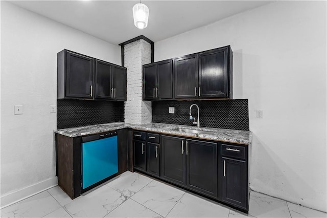 kitchen featuring light stone countertops, marble finish floor, tasteful backsplash, and a sink