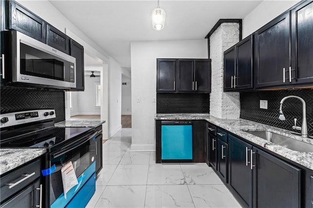 kitchen with light stone counters, marble finish floor, stainless steel appliances, decorative backsplash, and a sink