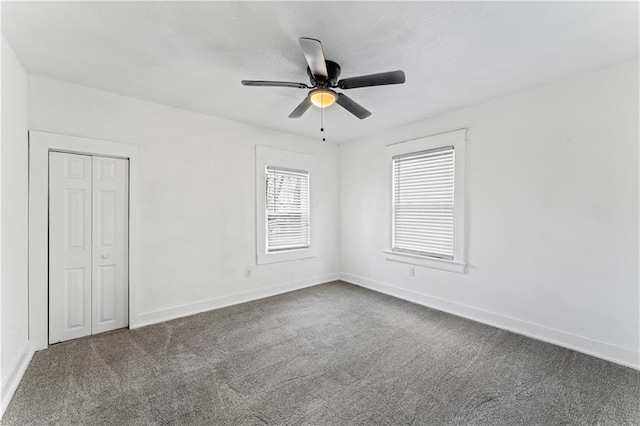 unfurnished bedroom featuring ceiling fan, a closet, carpet flooring, and baseboards