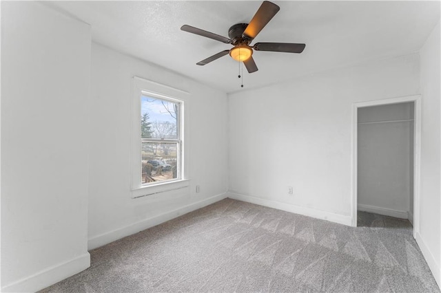 spare room featuring carpet flooring, a ceiling fan, and baseboards