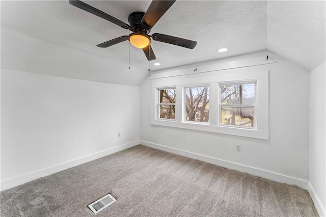 bonus room featuring baseboards, visible vents, vaulted ceiling, a textured ceiling, and carpet flooring