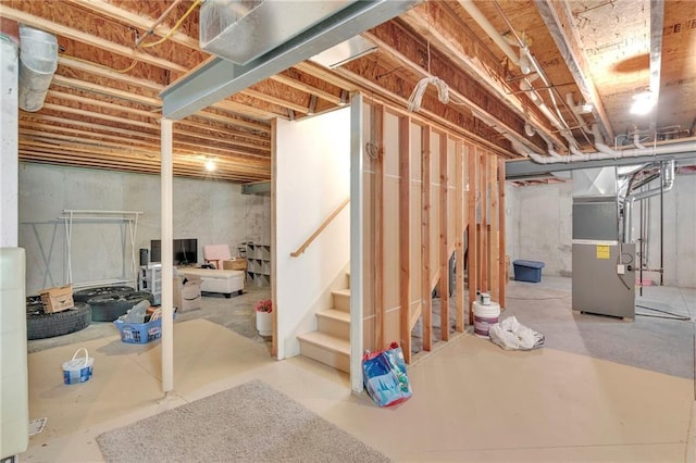 unfinished basement with stairway and heating unit