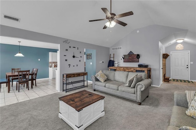 living room featuring ceiling fan, lofted ceiling, visible vents, and light carpet