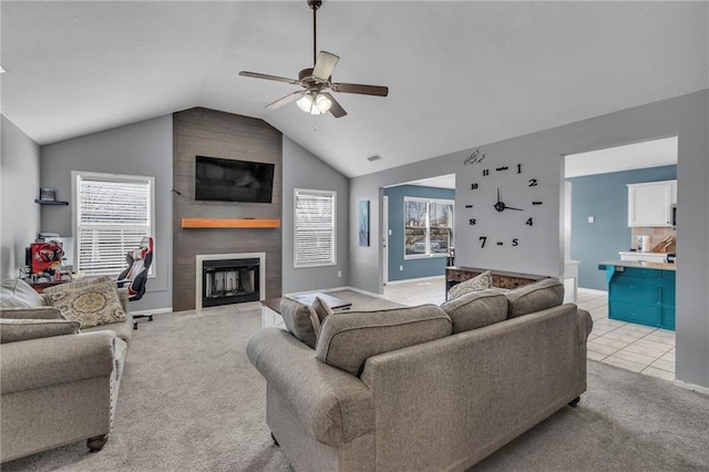 living area featuring a fireplace, lofted ceiling, light colored carpet, and a ceiling fan