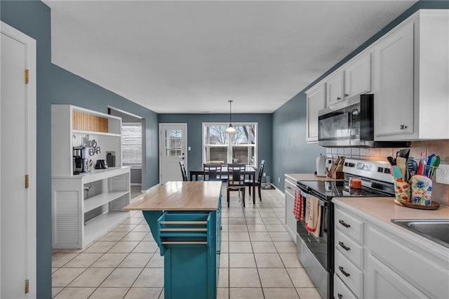 kitchen with white cabinets, light tile patterned floors, and appliances with stainless steel finishes