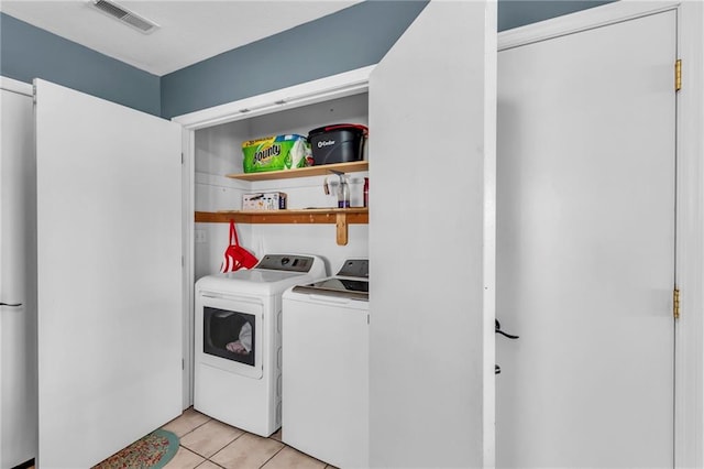 washroom with light tile patterned flooring, visible vents, laundry area, and separate washer and dryer