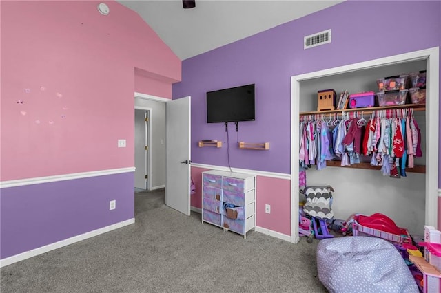 carpeted bedroom featuring a closet, visible vents, baseboards, and lofted ceiling