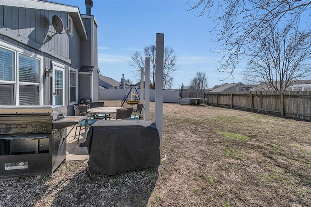 view of yard featuring a patio, a trampoline, and a fenced backyard