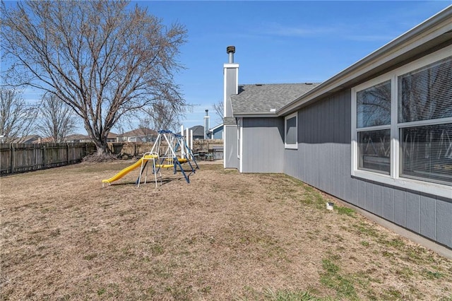 view of yard featuring a playground and fence