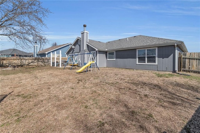 back of house featuring a playground, a fenced backyard, and roof with shingles