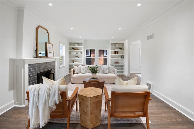 sitting room featuring visible vents, baseboards, ornamental molding, arched walkways, and dark wood-style flooring